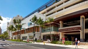a large building with palm trees in front of a street at HEART of WAIKIKI,1BDRM,FREE PARKING, WIFI,NO RESORT FEES,YOUTUBE,NETFLIX ! in Honolulu