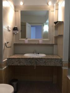 uma casa de banho com um lavatório e um espelho em Apartamentos DELFIN em Es Calo