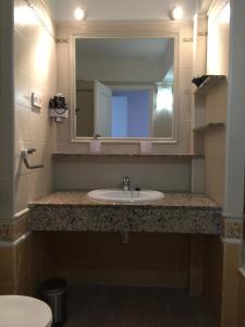 a bathroom with a sink and a mirror at Apartamentos DELFIN in Es Calo