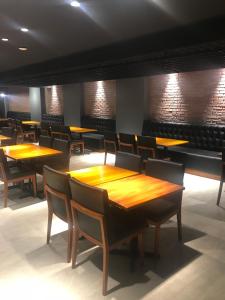 a dining room with wooden tables and chairs at Taos Apart Hotel in Santa Cruz de la Sierra