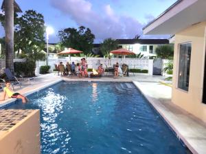a group of people sitting around a swimming pool at Colony Club Inn & Suites in Nassau +60 photos