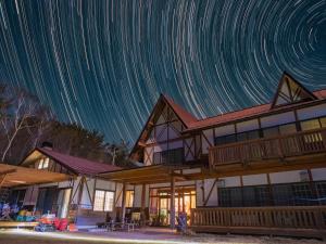 a house with star trails in the sky at Iwane Sanso in Kawakami