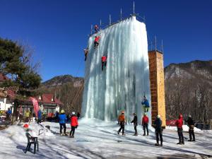 a group of people are climbing on a ice wall at Iwane Sanso in Kawakami