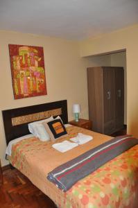a bedroom with a bed and a dresser in it at Hostal Goya Andina in Cusco