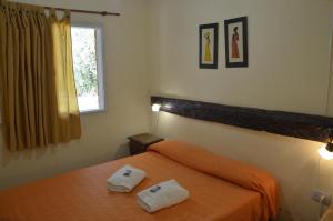a bedroom with a bed with two towels on it at Complejo de Cabañas Pach - Flo in San Marcos Sierras +88 photos