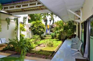 an outdoor patio with chairs and a garden at Jambura Inn in Gorontalo