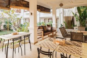 a patio with tables and chairs and a couch at Gerke House in Ubud