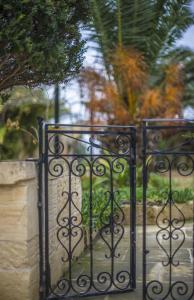 a pair of gates in front of a garden at Ta' Bertu Host Family Bed & Breakfast in Ħal Far