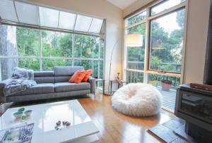 a living room with a couch and a large window at Tree Top Stay in Olinda