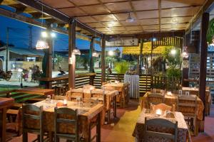 un restaurante con mesas de madera, sillas y luces en Wasai Puerto Maldonado Eco Lodge, en Puerto Maldonado