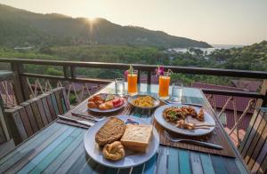 einen Tisch mit Teller mit Speisen auf dem Balkon in der Unterkunft Alama Sea Village Resort - SHA Extra Plus in Ko Lanta