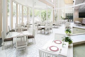 a restaurant with white tables and chairs and windows at City Plaza Osaka in Osaka