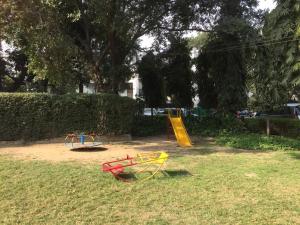 um parque infantil com um escorrega amarelo e um escorrega amarelo em Homestay Chateau 39 em Nova Deli