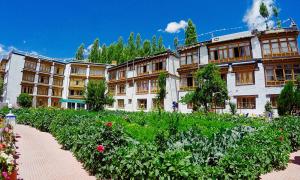 a large building with a garden in front of it at Oriental Hotel in Leh