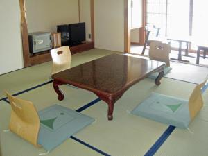 a living room with a coffee table and chairs at Kamikochi Nishi-itoya Mountain lodge in Matsumoto