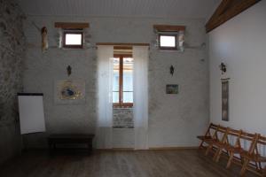um quarto com uma mesa e cadeiras e uma janela em Le Pèlerin em Montségur