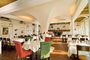 uma sala de jantar com mesas e cadeiras brancas em Restaurant-Hotel Seeblick em Mörigen
