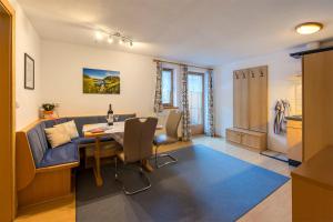 ein Wohnzimmer mit einem Tisch und einem blauen Sofa in der Unterkunft Landhaus Flunger in Sankt Anton am Arlberg