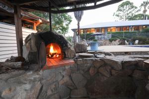 een stenen open haard voor een gebouw bij Samford Lakes Rural Accommodation in Mount Samson