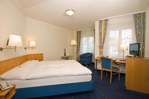 Cette chambre comprend un lit et un bureau. dans l'établissement Restaurant-Hotel Seeblick, à Mörigen