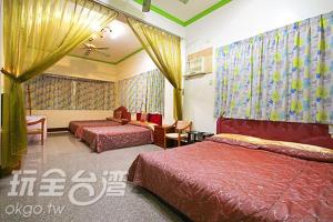 Cette chambre d'hôtel comprend 2 lits avec des couvertures rouges. dans l'établissement Sun Moon Flower Homestay, à Yuchi