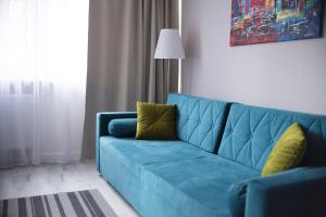 a blue couch in a living room with a lamp at Hosapartments City Center in Warsaw +108 photos