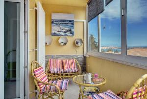 a porch with chairs and a table and windows at Apartman Mirna in Premantura