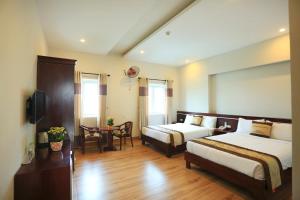 a hotel room with two beds and a table at Phuong Linh Hotel in Danang