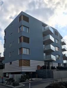 a large apartment building in front of a street at Close to Zürich centre and Airport in Kloten