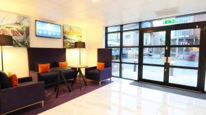 a lobby with a waiting area with chairs and a table at Citrus Hotel Cardiff by Compass Hospitality in Cardiff