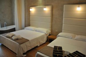 a room with two beds and a tub and a sink at AmbientHotels Panoramic in Rimini
