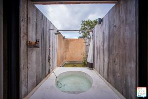 a bathroom with a bath tub in a wooden wall at COOLLiving Farmhouse Organic in Wang Nam Khieo