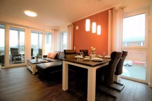 a living room with a dining table and a couch at Wohnen am Yachthafen W48 in Cuxhaven