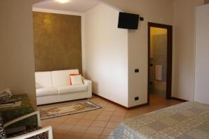 a living room with a white couch and a television at San Giorgio Lazise in Colà di Lazise