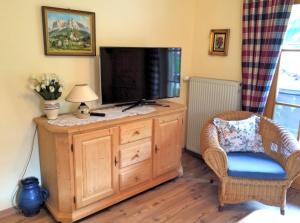 a living room with a television on a wooden dresser at Ferienwohnung Renate in Grainau