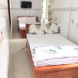 2 letti in una camera con pareti bianche di Nhà nghỉ Sunrise a Quy Nhon