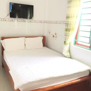 ein kleines Bett in einem Zimmer mit Fenster in der Unterkunft Nhà nghỉ Sunrise in Quy Nhon