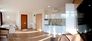 a kitchen with white cabinets and a table in a room at Siesta Apart Otel İzmir in İzmir