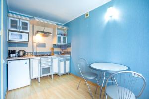 ムィコラーイウにあるApartment city centerの青い壁のキッチン(テーブル、椅子付)