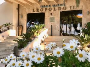 a building with white flowers in front of it at Hotel Terme Marine Leopoldo II TERME & SPA in Marina di Grosseto