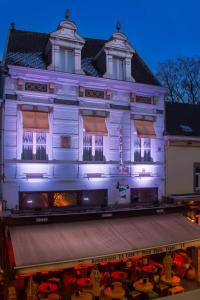 a white building with a stage in front of it at Hotel La Casa in Valkenburg