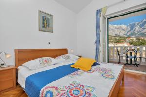 a bedroom with a bed with a view of a mountain at Guest house Villa Ana in Baška Voda