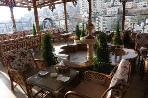 a restaurant with tables and chairs and a view of a city at Royal Suites in Nablus