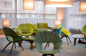 a living room filled with chairs and tables at Hotel Reina Petronila in Zaragoza