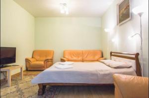 モスクワにあるNa Kirovogradskoy Apartmentのベッド1台、椅子2脚、テレビが備わる客室です。