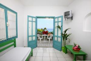 Cette chambre dispose d'une porte s'ouvrant sur un balcon avec une table. dans l'établissement Anatoli Apartments, à Chersónissos