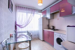 ムィコラーイウにあるЗатишна квартира у самому центрі , на Соборнійのキッチン(紫色のキャビネット、洗濯機付)