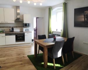 a kitchen and dining room with a wooden table and chairs at Alpenaquarium Grüblsee - FEWO Monika in Vordernberg