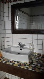 a bathroom sink with a mirror and a tile floor at Castillo Gualisancho in Echedo