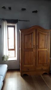 a bedroom with a wooden cabinet and a window at Castillo Gualisancho in Echedo